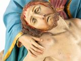statue of jesus on the cross holding the head of a woman