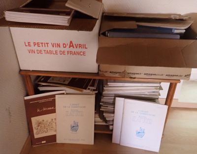 une pile de livres posée sur une étagère en bois, à côté d'une boîte