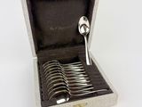 a box with six spoons in it on a white surface