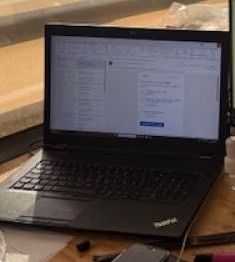 un ordinateur portable posé sur un bureau à côté d'un téléphone portable