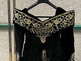 une robe noire et dorée suspendue à un portant