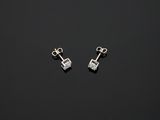 une paire de boucles d'oreilles en argent posées sur une surface noire