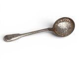 silver spoon on a white surface with a spoon in the middle