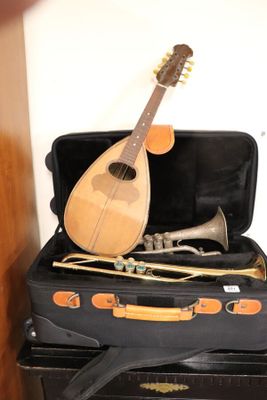 a guitar and a trumpet in a suitcase on top of a stack of suitcases