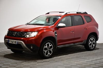 La Dacia rouge est garée sur un sol à damier.