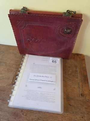 a red purse sitting on top of a table next to a book