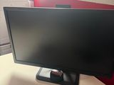 a computer monitor sitting on a desk in an office