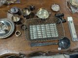a wooden table with a lot of silver items on it