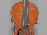 un vieux violon posé sur une table près d'un mur