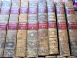 several old books are stacked on top of each other on a shelf