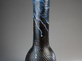 un vase noir et bleu posé sur une table