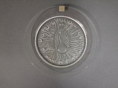 un plateau en argent orné d'un paon, posé sur une table