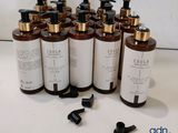 six bouteilles de liquide posées sur une table, à côté d'une bouteille de liquide