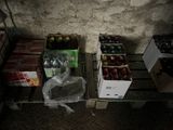 many boxes of soda sitting on a pallet next to a wall