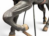 a wooden horse with a saddle on it ' s back