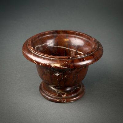 a brown marble bowl on a black surface