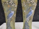 two vases with peacocks painted on them sitting on a table