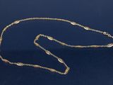 un collier plaqué or, composé d'une longue chaîne et d'un fermoir