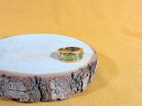 a ring sitting on top of a piece of wood