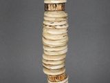 statue d'une femme vêtue d'une robe faite de coquillages et de perles