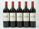six bouteilles de vin sont alignées sur une surface blanche