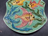 une assiette ornée d'un motif de poisson, posée sur une table