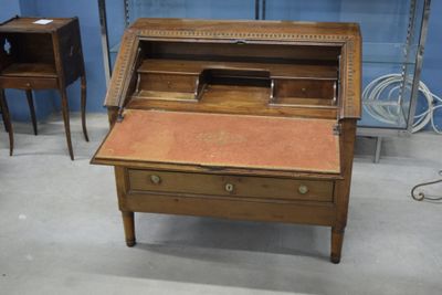 un petit bureau muni d'un tiroir, dans une pièce