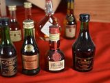 many bottles of alcohol on a red table cloth