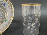two vases and a plate on a table with a black background