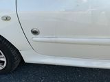 une petite voiture blanche garée sur le bord de la route