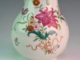 a white vase with a floral design on it