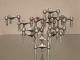 une sculpture métallique représentant un ensemble d'objets posés sur une table