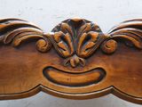 un gros plan d'un banc en bois sculpté sur lequel figure un visage