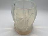 a clear glass bowl with a wooden base on a white surface