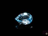 un gros plan d'une topaze bleue et d'un diamant sur une surface noire