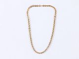 a gold chain necklace with a small bead on a white background