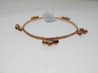a close up of a gold bracelet on a white surface