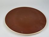 a brown plate on a white table with a white background