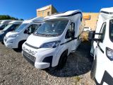 de nombreuses camionnettes blanches garées en rangée sur un parking