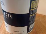 a close up of a can of paint on a wooden table