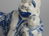 a small figurine of a man holding a baby