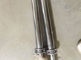 two metal straws sitting on the floor next to each other
