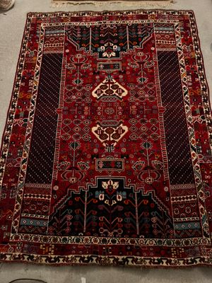 un grand tapis rouge posé par terre à côté d'une chaise
