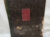 un vieux livre à la couverture rouge posé sur une surface blanche