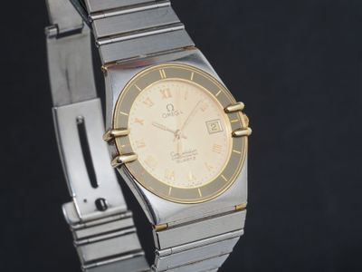 une image représentant une montre en or et en argent sur fond noir