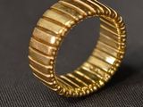 gros plan d'une bague en or sur une surface noire