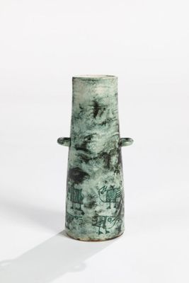 a green vase that is sitting on a white surface