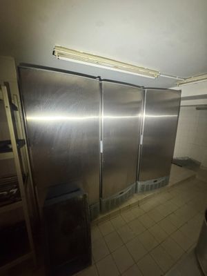 stainless steel refrigerators in a commercial kitchen with tiled flooring