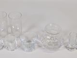 a lot of glass vases and glasses on the table