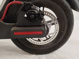 a black scooter with a red brake and a black wheel